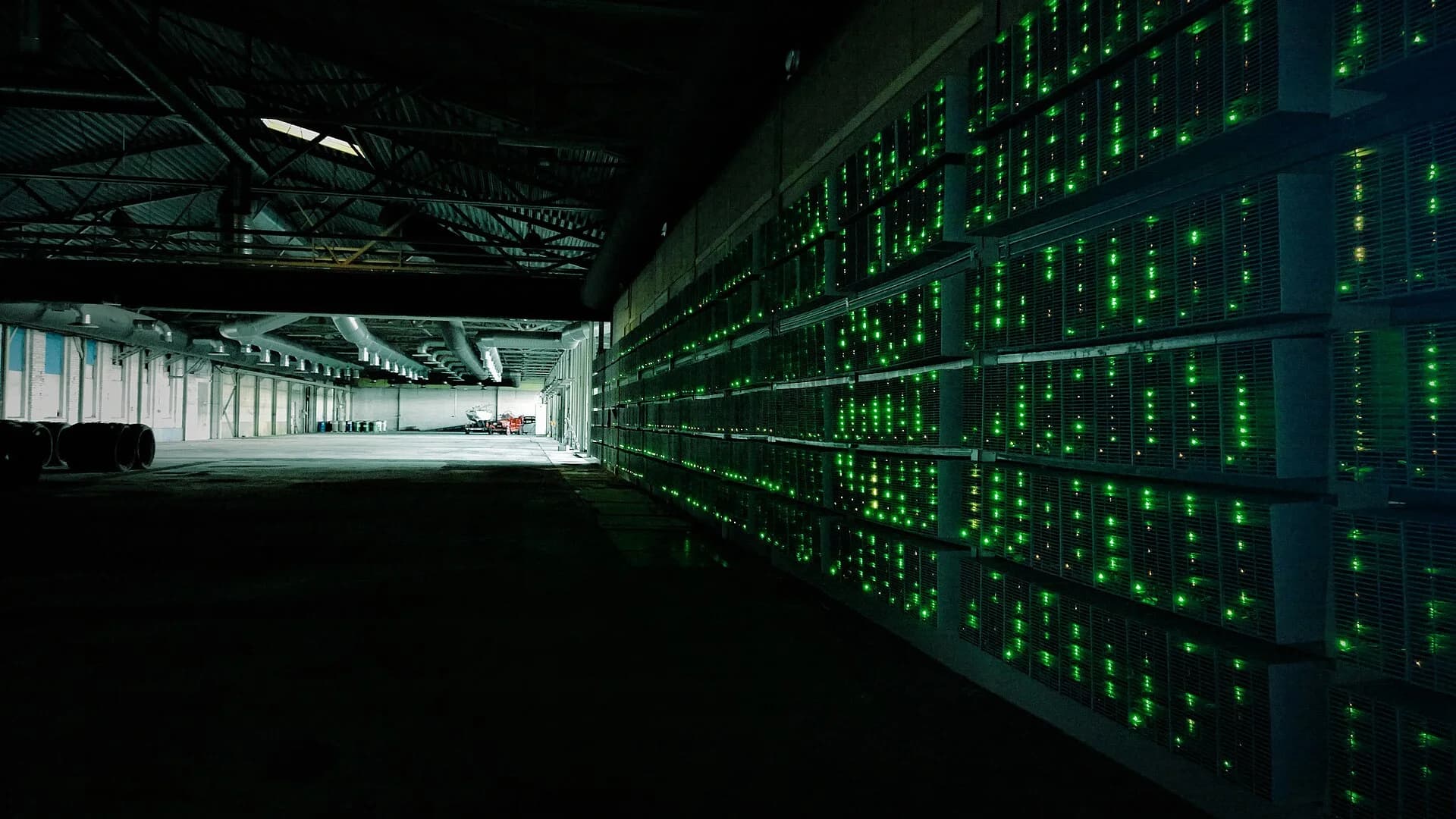 Racks of ASIC machines inside a Bitcoin mining farm (photo: Marko Ahtisaari, Wikimedia Commons, CC BY 2.0)