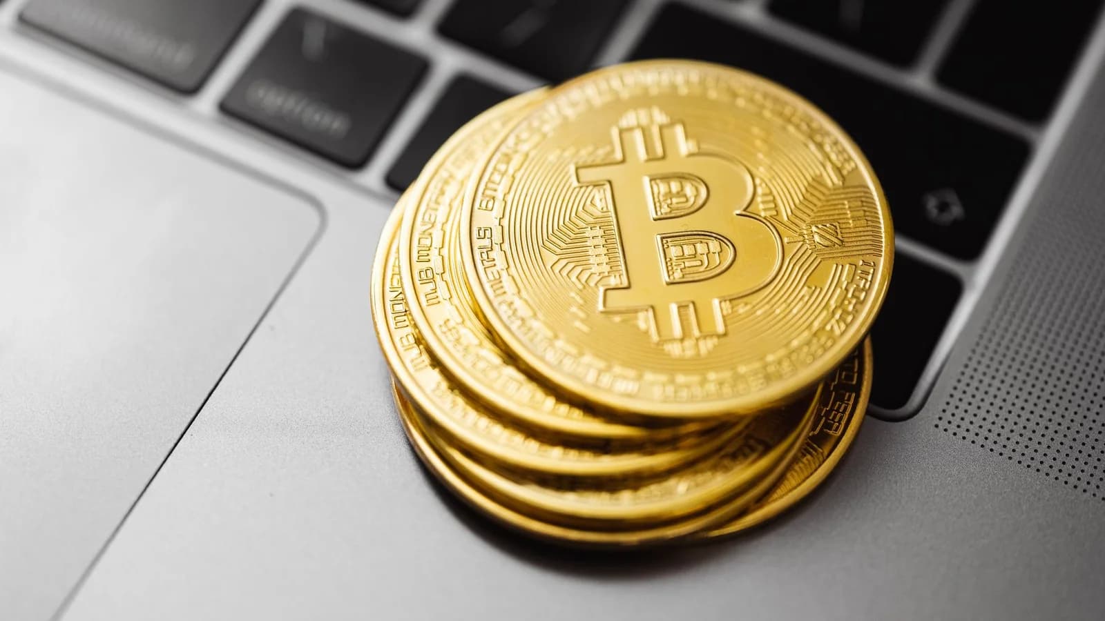 Bitcoin coins stacked on a laptop keyboard