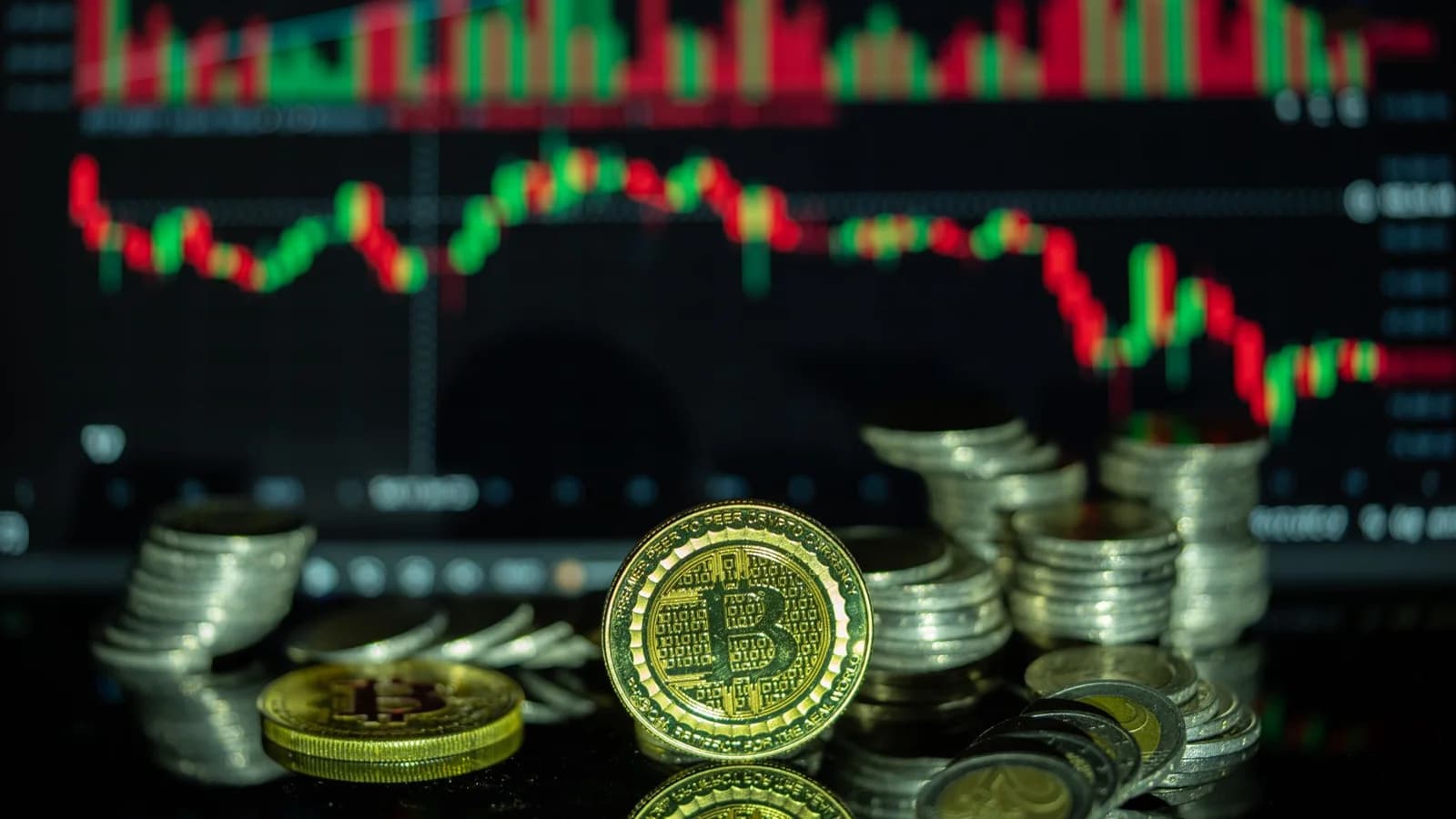 Golden Bitcoin and stacked coins in front of a colorful financial chart, symbolizing cryptocurrency market dynamics.