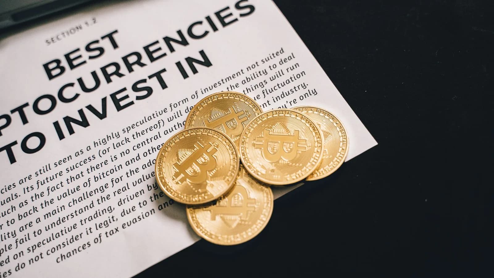 Close-up of Bitcoin coins on investment document promoting cryptocurrencies.